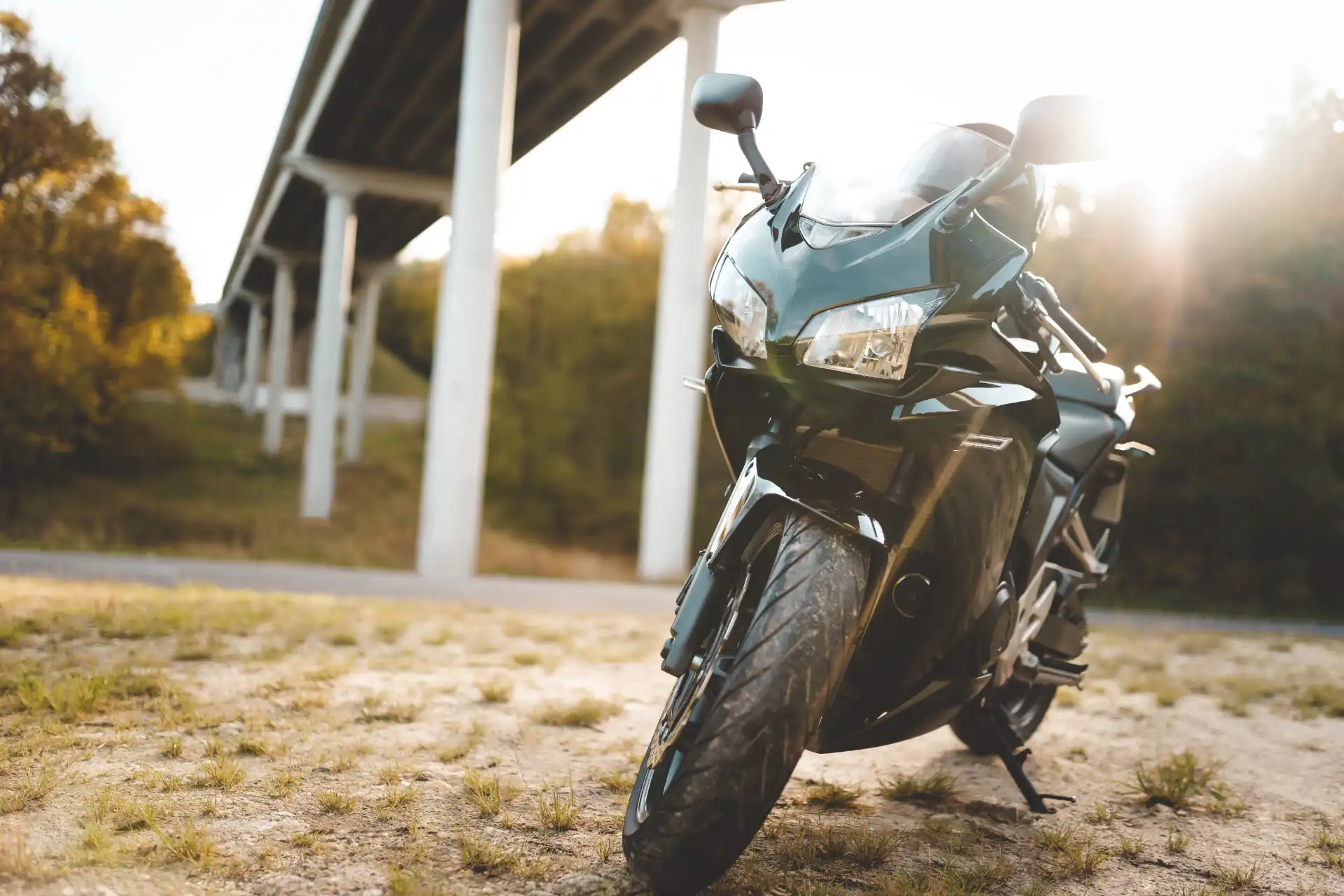 fast black sports bike parked near bridge